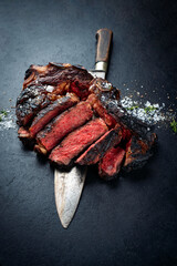 Barbecue dry aged chianina rib of beef steak served with crystal salt and thyme as close-up on a...