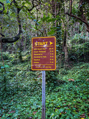 Sign marking the start of Kalalau Trail on the Hawaiian island of Kauai, USA with distances to several points of interest