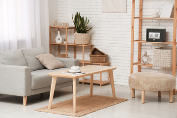 Interior of living room with sofa, table and modern safe on shelf