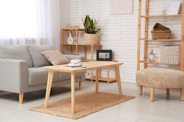 Interior of living room with sofa, table and modern safe on shelf