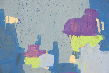 Fototapeta premium Messy paint strokes and smudges on grunge painted cement stucco wall background. Creative modern urban city background with blue, purple, yellow color drips, flows, streaks of paint and paint sprays