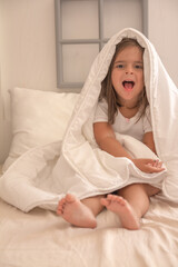 the little girl playing and tickling on the bed and having fun