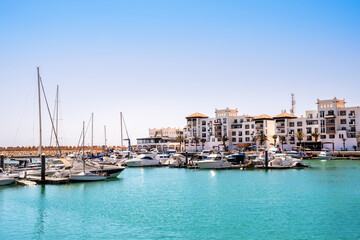 Agadir Marina in Morocco. Popular tourist area with luxury apartments, boats in harbor, shops and restaurants. Moroccan seaside resort on shore of Atlantic ocean in Africa