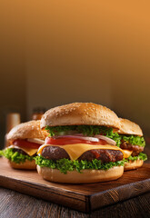 Tres hamburguesas con queso, tomate, lechuga y cebollas, presentadas en vertical con espacio para completar. Ilustración IA generativa 