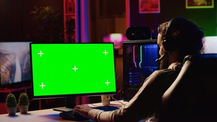 Player having fun by using isolated screen computer monitor to play singleplayer videogame. Professional gamer using chroma key PC desktop to complete levels in game, talking with friends