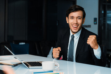 Portrait of successful happy young businessman smiling and looking at camera. Business success and...