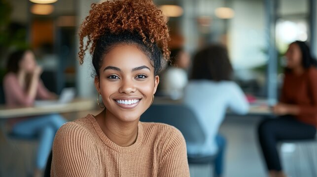 Friendly portrait of a young African American woman with curly hair at a casual business meetup
