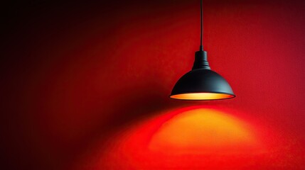 Obraz premium A single black lamp hangs from a ceiling. This photo is perfect for projects about interior design, lighting, or mood.