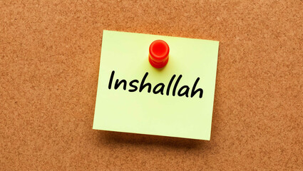 inshallah word written on a note sticky on corkboard