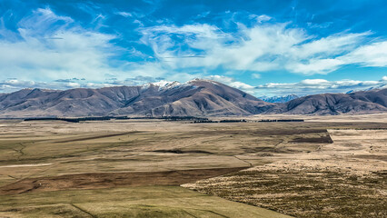 The way to Lake Ohau and the southern alps through alpine grasses and tundra terrain
