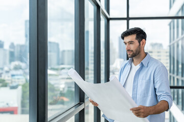 Fototapeta premium Professional architect engineer or male worker in casual outfit looking at skyscraper and city view while holding project plan. Creative design, civil engineering, building construction. Tracery.