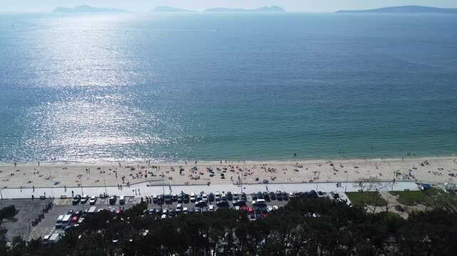 Aerial view of Playa de Samil, the main beach of Vigo in Galicia in northwest Spain. Sunny day, crystal clear blue sea. Houses, streets. Drone take.