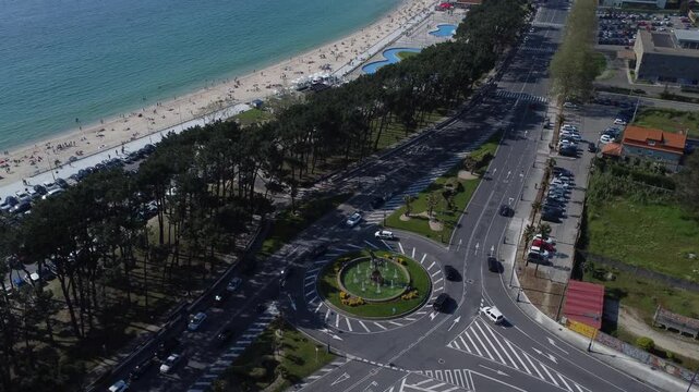 Aerial view of Playa de Samil, the main beach of Vigo in Galicia in northwest Spain. Sunny day, crystal clear blue sea. Houses, streets. Drone take.