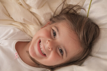 the little girl playing and tickling on the bed and having fun