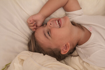 the little girl playing and tickling on the bed and having fun