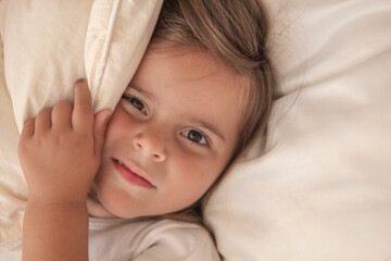 the little girl playing and tickling on the bed and having fun