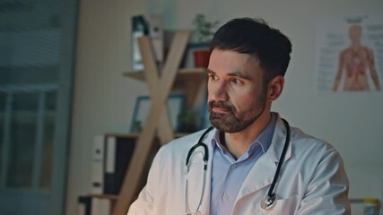 Tired physician rubbing eyes in night clinic. Closeup doctor typing computer