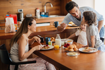Happy family enjoying breakfast together in cozy kitchen