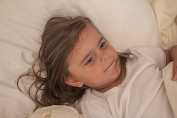 the little girl playing and tickling on the bed and having fun