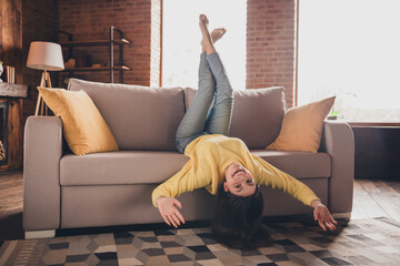 Full length photo of nice teen lady lying sofa upside down have fun dressed yellow garment spend...