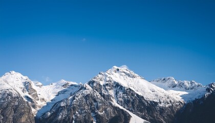 Majestic snow-capped mountain peaks under a clear blue sky in winter