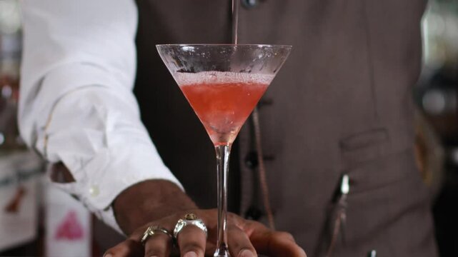Black bartender preparing a cocktail in a traditional cocktail bar
