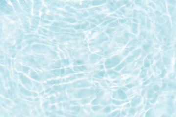 Blue water with ripples on the surface. Defocus blurred transparent blue colored clear calm water surface texture with splashes and bubbles. Water waves with shining pattern texture background.