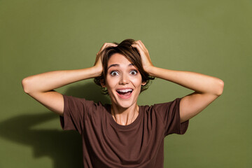 Photo portrait of pretty young girl touch head excited cheerful dressed stylish brown outfit isolated on khaki color background