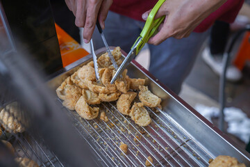 Fried meatballs are being cut into pieces using scissors