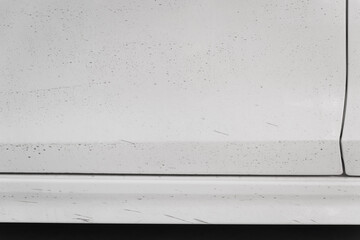 A close-up shot of a muddy sedan captures the rugged exterior, showcasing dirt splattered across...