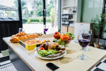 A business office is set for a Halloween party, with food spread across a desk pizza, bread, chicken grill, French fries, salad, and beer ready for celebration, but no people present.