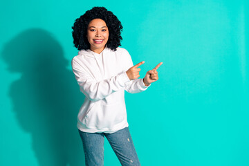 Photo portrait of young funny chevelure hairstyle lady wearing white hoodie point fingers empty blank space isolated on cyan color background