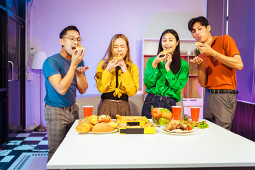 A group of Asian friends gathers in an office for a night of BBQ, pizza, and drinks, celebrating Halloween with vibrant RGB lighting, laughter, and cheering for their favorite soccer team.