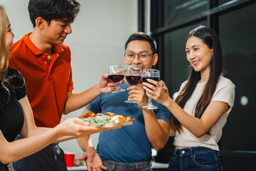 Asian office colleagues and friends enjoy a daytime BBQ with pizza and beer, celebrating Halloween and cheering for their favorite soccer team, creating a lively atmosphere filled with joy.