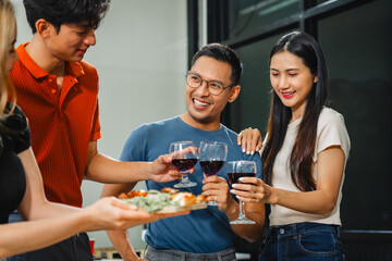 Asian office colleagues and friends enjoy a daytime BBQ with pizza and beer, celebrating Halloween and cheering for their favorite soccer team, creating a lively atmosphere filled with joy.