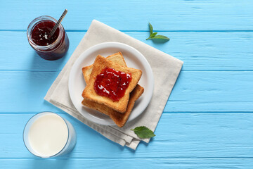 Delicious toasts with jam and milk on light blue wooden table, flat lay