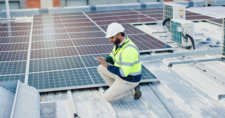 Technician, man and tablet for solar panels, energy saving and electricity or heating of eco friendly grid on rooftop. Engineering, digital technology and photovoltaic inspection for installation © WesLens/peopleimages.com