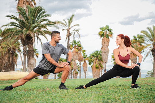 A young athletic couple stretching their muscles with yoga poses after a fitness workout on the coast. Two sporty people enjoying an outdoor Pilates session to improve their health and flexibility