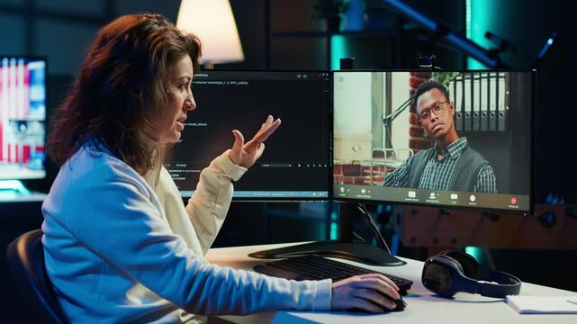 Woman doing software debugging helped by coworker in videocall, checking errors in lines of code. Programmer working from home fixing coding mistakes, assisted by colleague in teleconference, camera A