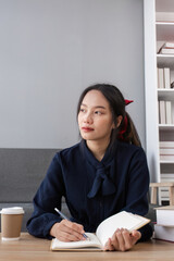 Focused Girl Studying Online with Notebook and Coffee in Modern Home Setting