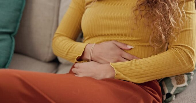 Living room, sofa and hands of woman with stomach pain for diarrhea, menstruation and constipation. Female person, home and abdomen with tummy ache for ibs cramps, digestion problem and gastro issue