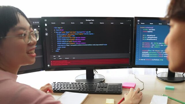 Slow motion back end software developer engineer for computer programming working together on debugging writing computing code, solving complex algorithms display on monitor in office. Burgeoning