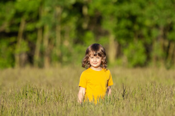 Country girl is walking in the fescue field in hot summer.