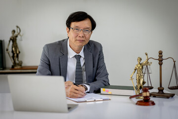 Serious pensive lawyer working at desk in office. Legal law, documents, advice and justice concept.