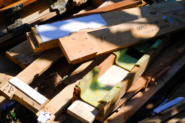 Pile of wooden packaging waste on the side of the road. Closeup shot of scattered wooden planks. Wood industry. Packaging industry. Backgrounds and wallpaper. Background Photography Concepts. 