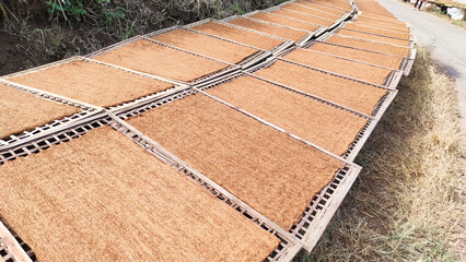 Background of Chopped Tobacco Leaves. Dried tobacco leaves that have been chopped are dried on a tray on the side of the road. Cigarette and Tobacco Industry. Tobacco texture background