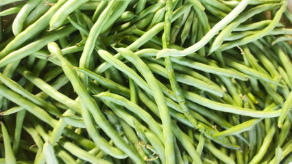 Texture of Pile of Green Beans (Phaseolus vulgaris). Randomly stacked vegetables sold in Traditional Market. Textured Details. Fresh food ingredients. Wallpaper Backgrounds Photography Concepts