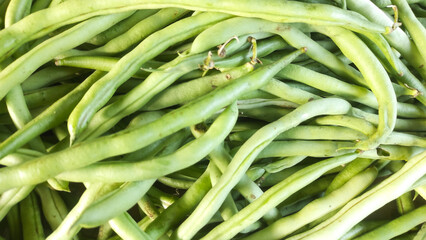 Texture of Pile of Green Beans (Phaseolus vulgaris). Randomly stacked vegetables sold in Traditional Market. Textured Details. Fresh food ingredients. Wallpaper Backgrounds Photography Concepts