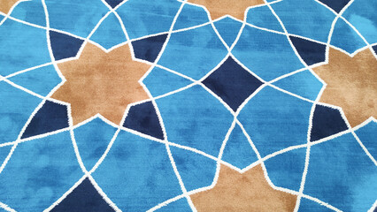 Texture and details of Mosque Carpet with triangle pattern forming a star. Mosque Carpet in blue and brown. Wallpaper and backgrounds. Textured Effects photography Concepts