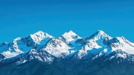 Obraz premium Majestic Snow-Capped Mountain Range Under Clear Blue Sky in Winter
